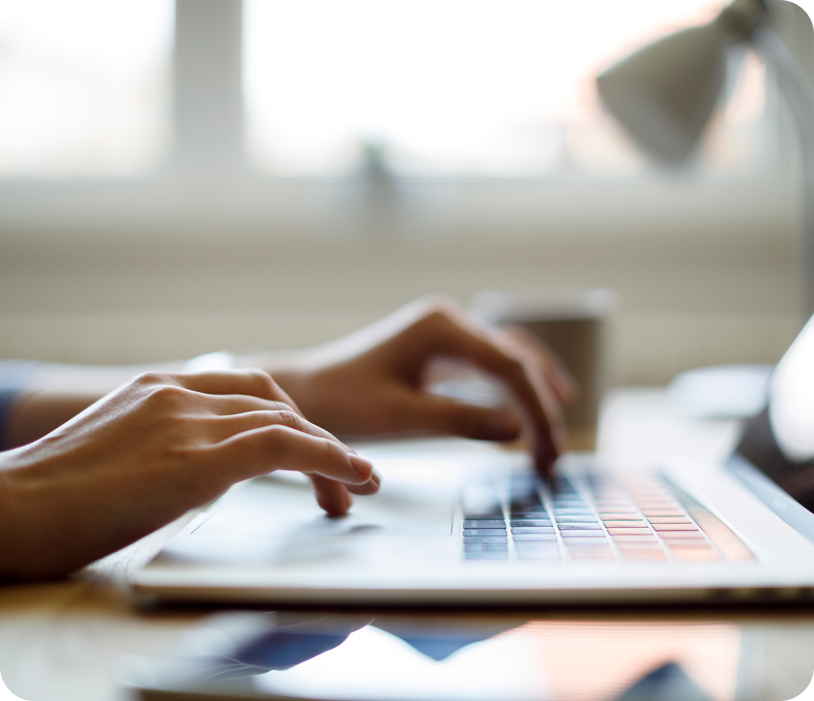 Hands typing on a laptop keyboard.