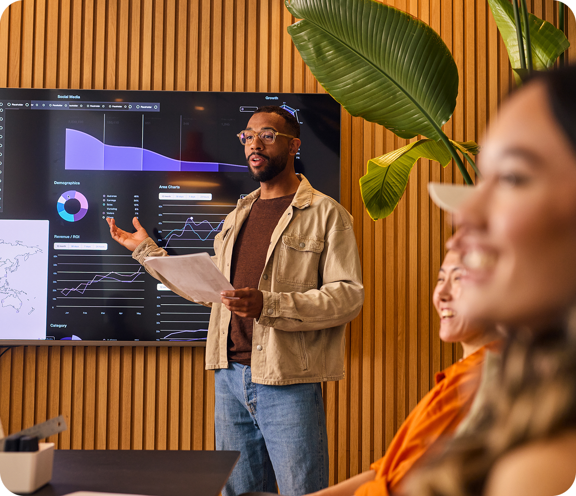 Man presenting data to colleagues in meeting.