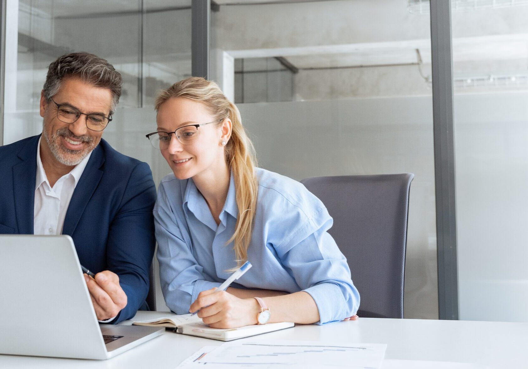 Man and woman working on laptop together.